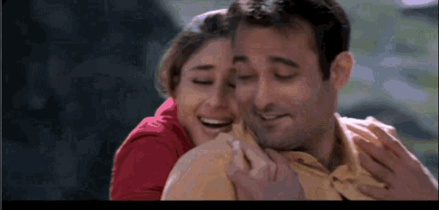 a man and a woman are hugging and smiling for the camera