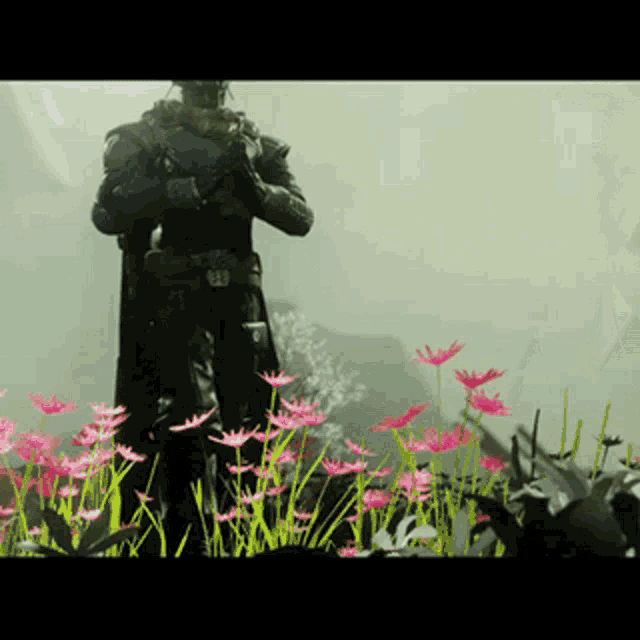a statue of a man in armor standing in a field of flowers