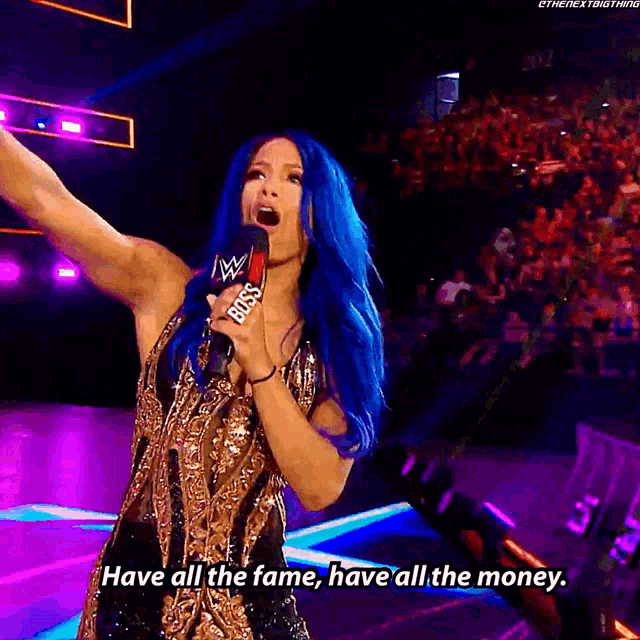 a woman with blue hair is holding a microphone and saying " have all the fame have all the money "