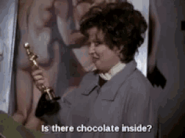 a woman is holding a trophy and asking if there is chocolate inside .
