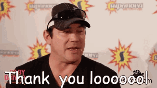 a man wearing a hat and sunglasses says " thank you loooood "