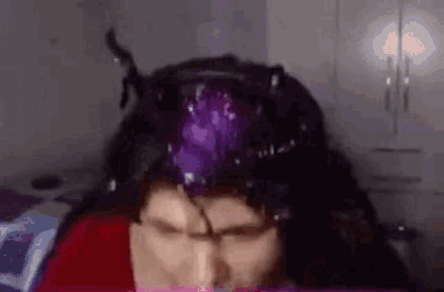 a close up of a person 's head with a purple wig on it .