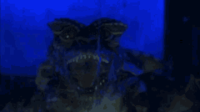a gremlin is coming out of the water in the dark .