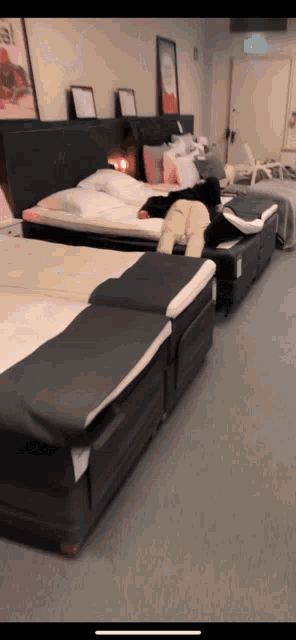 a person is laying on a bed in a store with a sign that says ' ikea ' on it