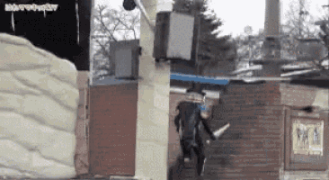 a man is jumping over a brick wall in front of a sign that says nba