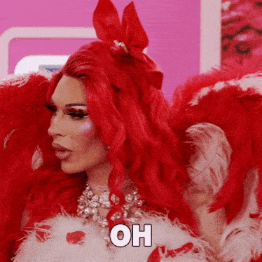 a drag queen with red hair and white feathers is wearing a costume that says oh