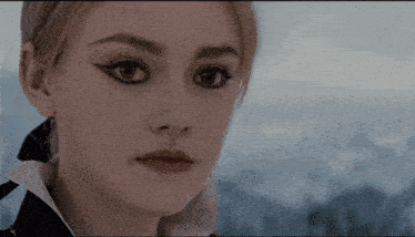 a close up of a woman 's face with red eyes and black eyeliner