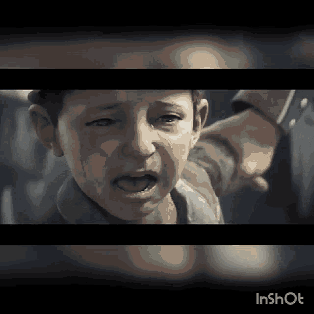 a little boy is crying and being held by a person