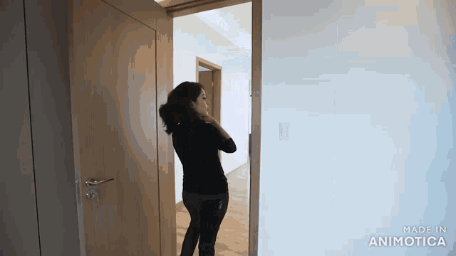 a woman is standing in a room with a door open and made in animatica