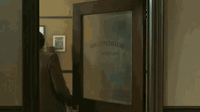 a man is standing in a doorway that says abrapplebaum detective