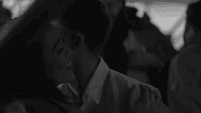a man and a woman are dancing together in a black and white photo . the man is wearing headphones .