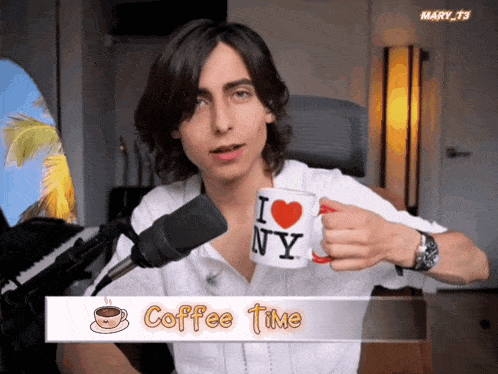 a man holding a mug that says i heart ny