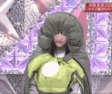 a woman is wearing a green sleeping bag with the word fuji on the front
