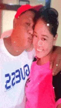 a man kisses a woman on the cheek while wearing a white shirt with the number 2230 on it