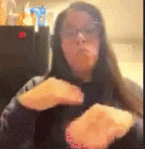 a woman wearing glasses is eating a piece of food .