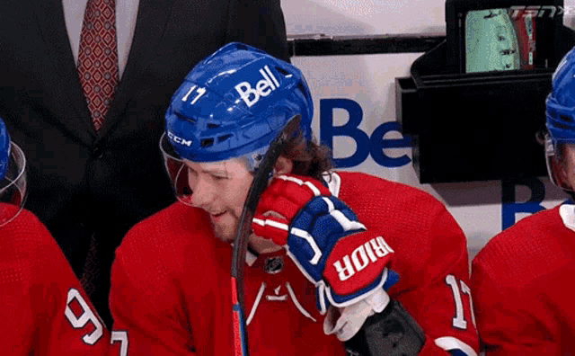 a hockey player wearing a blue helmet that says bell