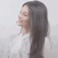 a woman with long dark hair is wearing a white shirt and a white tie .