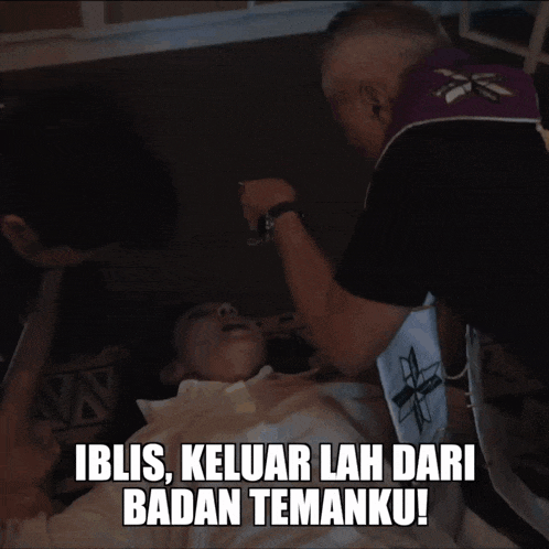 a man praying over a child with the caption iblis keluar lah dari badan temanku!