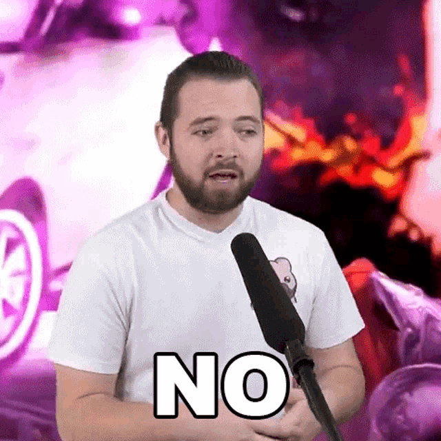 a man with a beard is standing in front of a microphone and saying no .