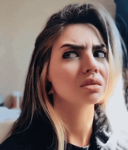 a woman with a nose ring is making an angry face
