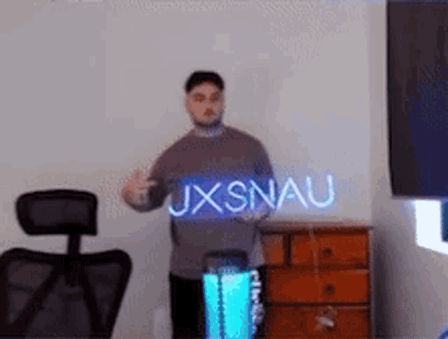 a man is standing in a room holding a sign that says ux snau .
