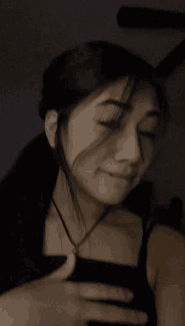 a woman in a black tank top is taking a selfie