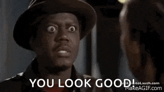 a man in a hat is talking to a woman and the words `` you look good '' are on the screen .