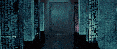 a dark hallway with a red light coming through the doorway