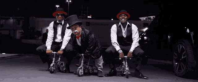 a man in a top hat is sitting next to two other men