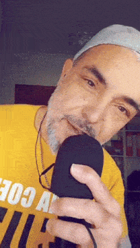 a man with a beard wearing a yellow shirt that says 103 at the bottom
