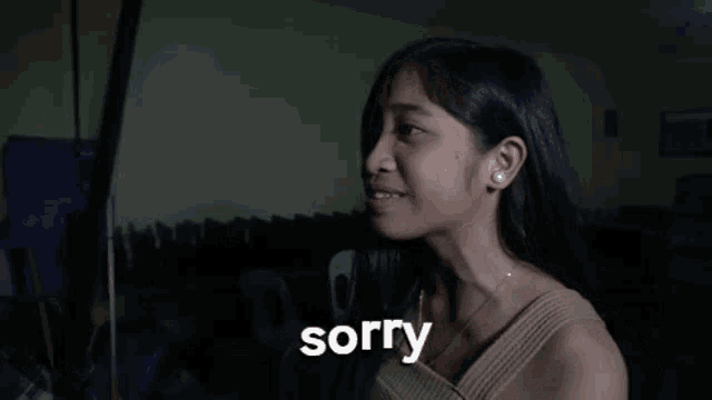 a woman is saying sorry in a dark room