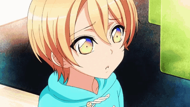 a little girl with yellow hair and blue eyes is wearing a blue sweatshirt