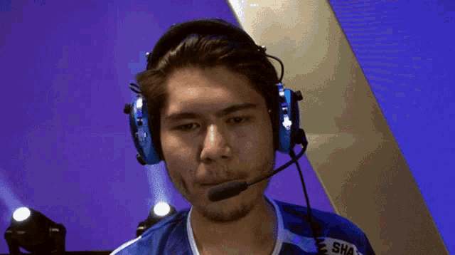 a man wearing a headset with the word sha on his shirt