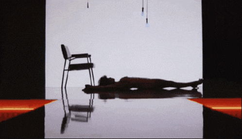 a woman is laying on the floor next to a chair