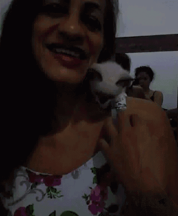 a woman in a floral dress is holding a cat