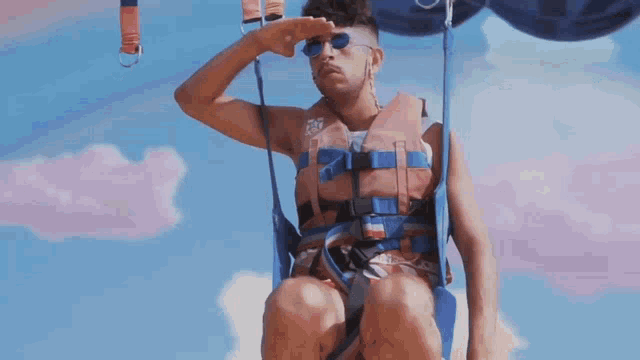 a man wearing sunglasses and a life vest with the number 25 on it