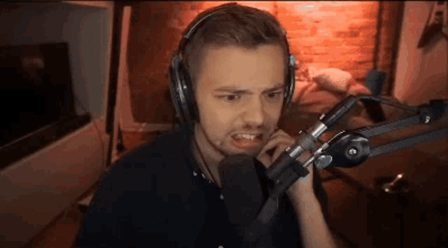 a man wearing headphones is talking into a microphone in a room .