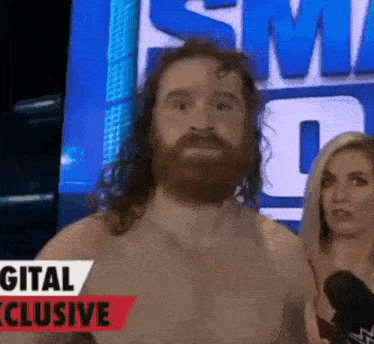 a man with a beard and long hair is standing in front of a microphone .