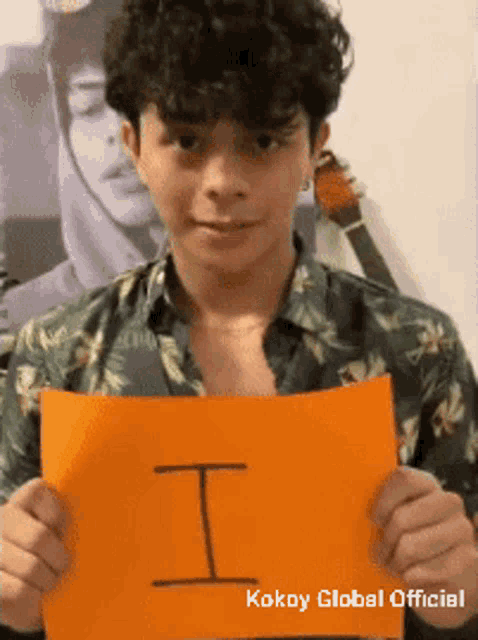 a young man is holding a piece of paper that says kokoy global official