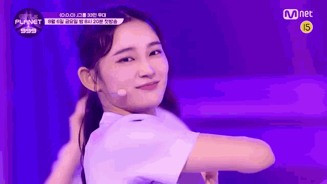 a girl is standing on a stage with a microphone in her hand .