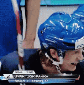 a hockey player in a blue helmet is laying on the ground
