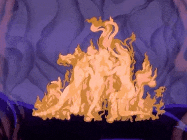 a group of people are standing on top of a pile of flames in a cave .