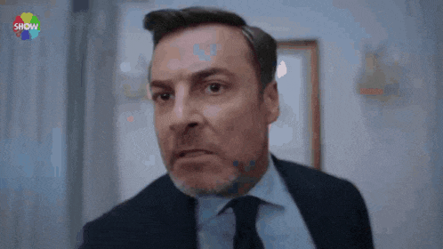 a man in a suit and tie is making a funny face