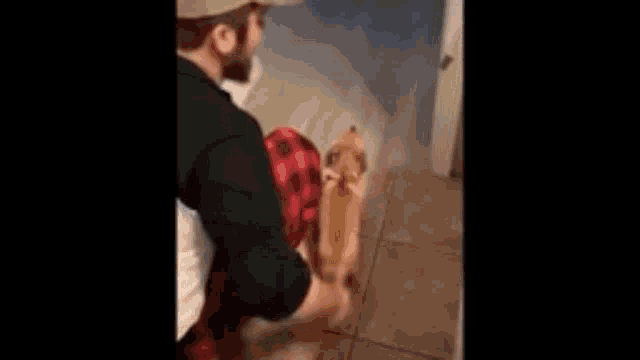 a man in a baseball cap is standing in a bathroom next to a toilet .