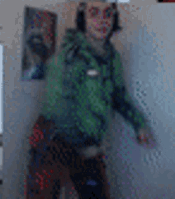 a blurry picture of a man wearing headphones and a green hoodie .