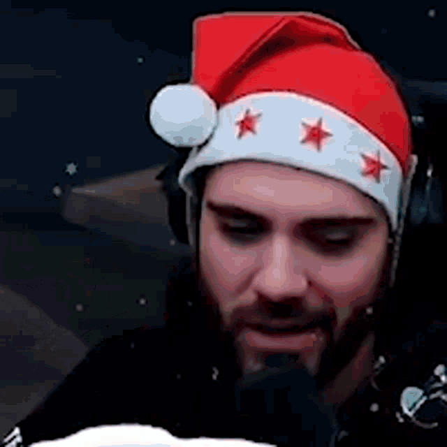 a man with a beard wearing a santa hat with three stars on it