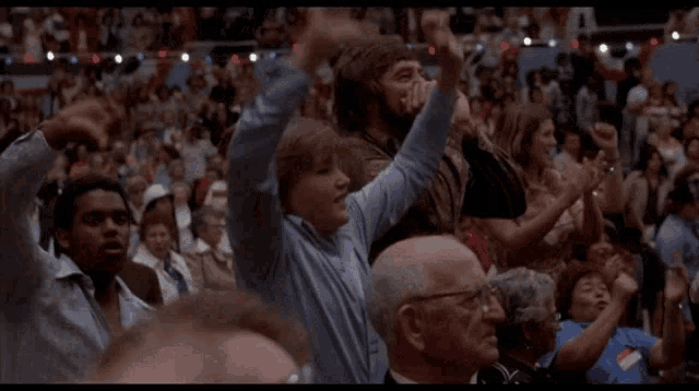 a crowd of people with their arms in the air including a woman with a name tag that says ' a ' on it