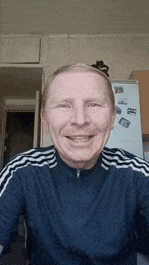 a man is smiling in front of a fridge that has a picture of a man on it