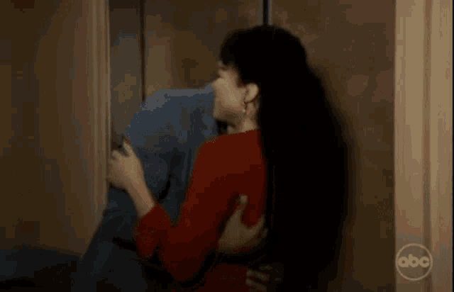 a woman is kissing a man on the cheek in front of a wall .