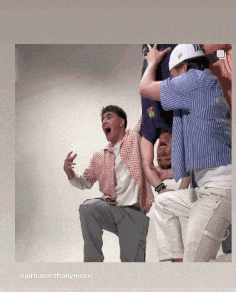 a group of young men are posing for a picture and one of them is holding another man 's pants